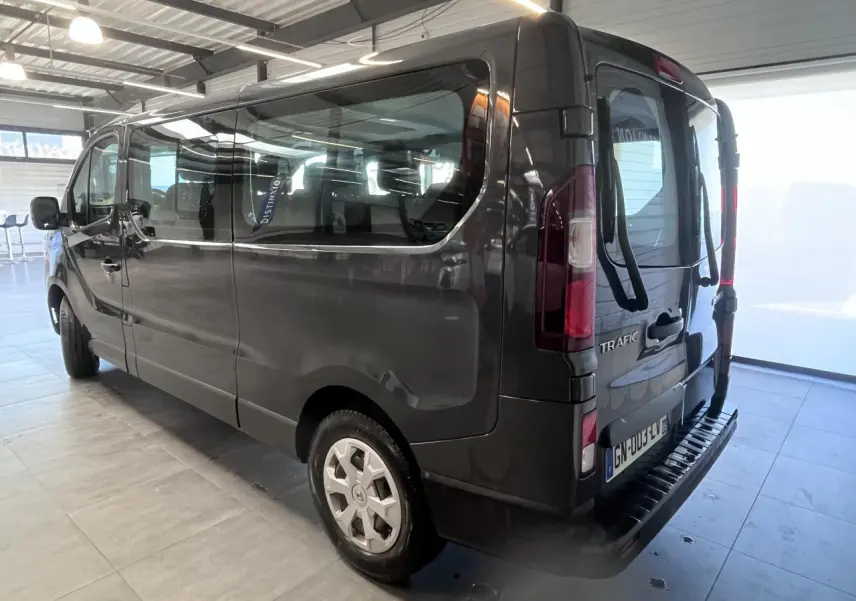 Vue 3/4 arrière droit du Renault Trafic Fourgon gris foncé avec portes arrière vitrées et porte-vélos installé.