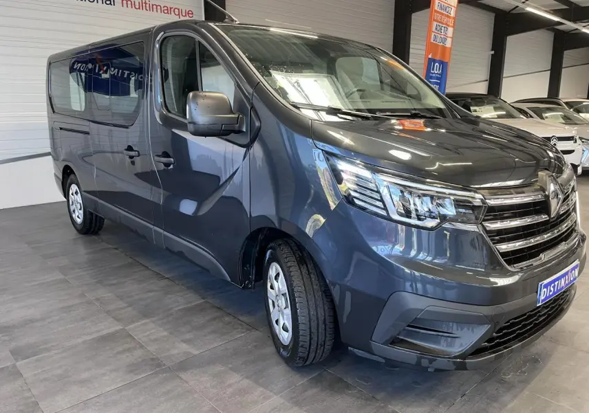 Vue 3/4 avant gauche d'un Renault Trafic Fourgon gris foncé avec projecteurs Full LED et vitres teintées.
