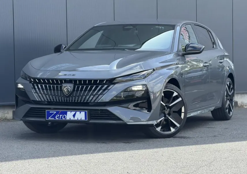 Peugeot 308 gris Selenium vue 3/4 avant droit, calandre noire distinctive et jantes alliage bi-ton.