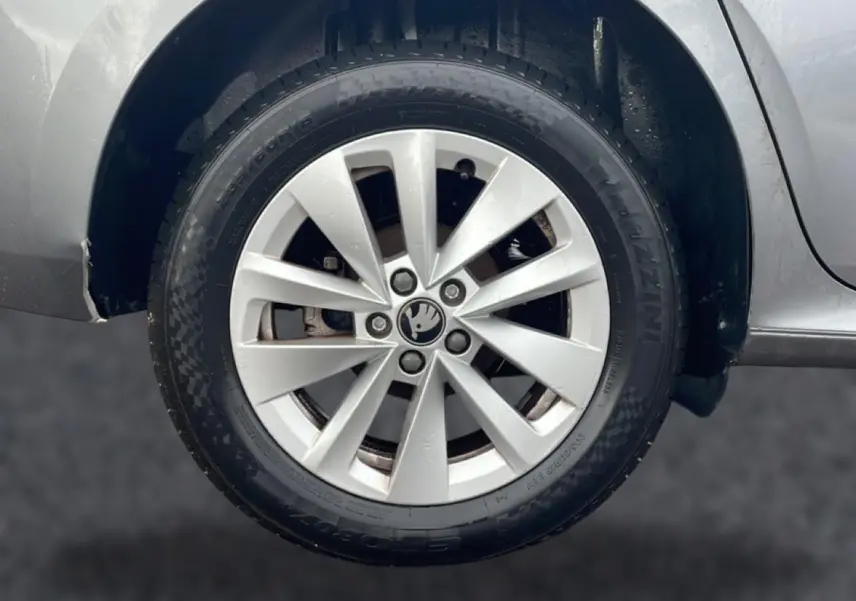 Gros plan sur la roue avant droite grise d'une Skoda Kamiq 2025 avec jante alu et logo au centre.