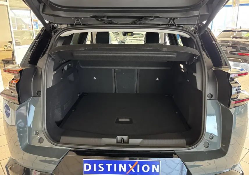 Coffre ouvert vu de l'arrière d'un Citroën C5 Aircross vert métallisé avec feux arrière LED et hayon levé.