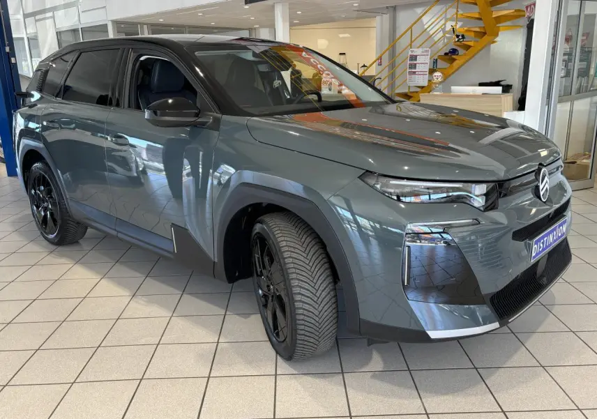 Vue 3/4 avant gauche du Citroën C5 Aircross vert avec jantes alliage noires et calandre noir brillant en showroom.