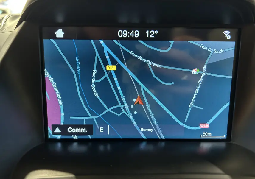 Écran tactile intérieur du Ford Kuga affichant la navigation GPS avec carte détaillée et indications de rues.