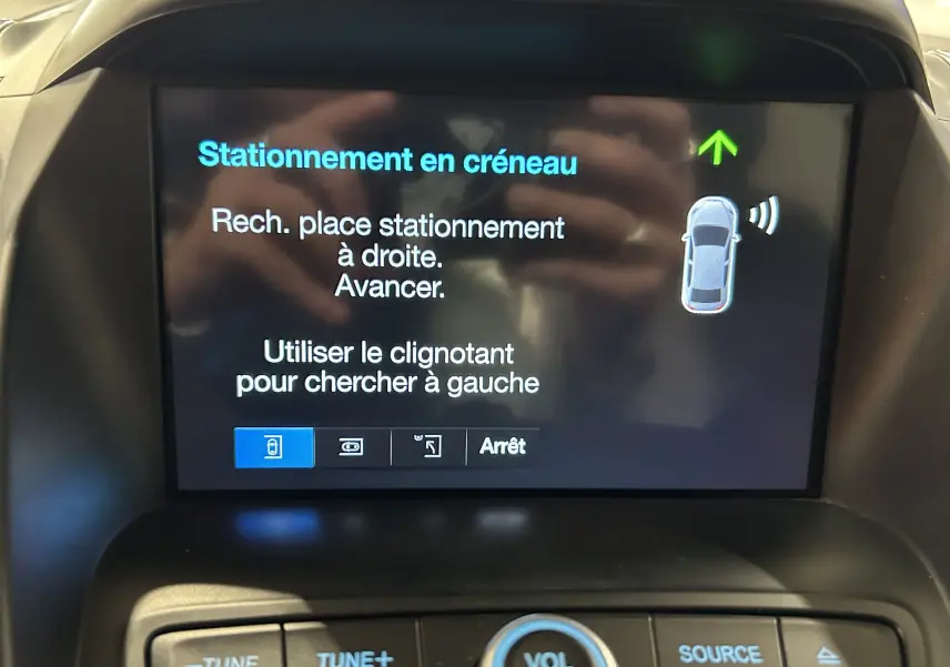 Écran central du Ford Kuga noir 2017 affichant l'assistance au stationnement en créneau avec instructions en français.