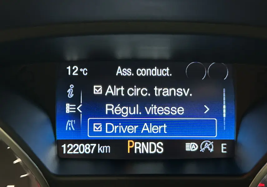Affichage du tableau de bord du Ford Kuga noir, montrant les options d'assistance à la conduite et le compteur kilométrique à 122087 km.
