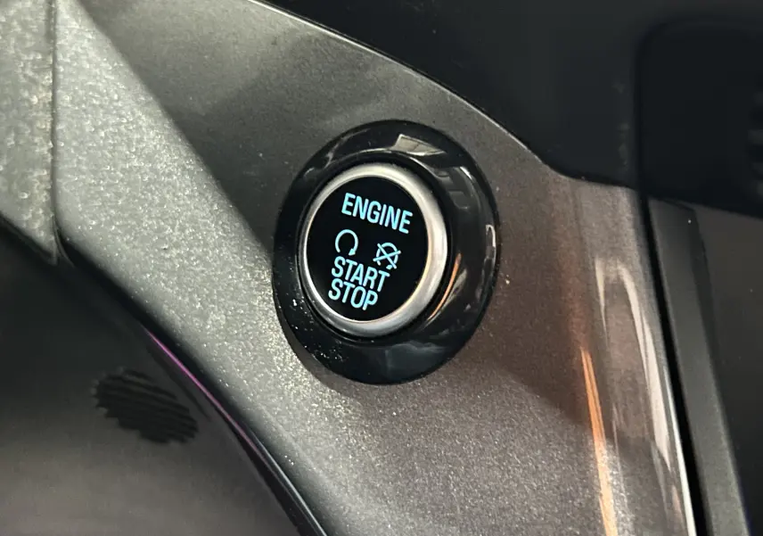 Gros plan sur le bouton start/stop moteur éclairé en bleu dans l’habitacle du Ford Kuga noir 2017.