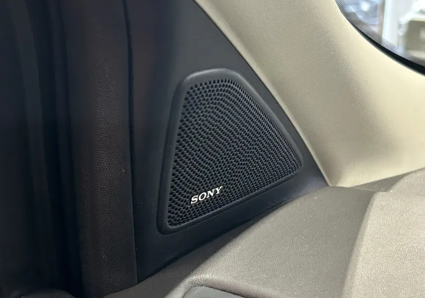 Gros plan sur le haut-parleur Sony noir intégré côté gauche de l’habitacle du Ford Kuga TDCI 2017.