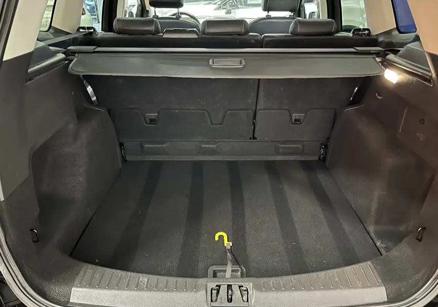 Vue intérieure du coffre noir du Ford Kuga TDCI 180 BVA Powershift 4x4 Vignale, avec cache-bagages déployé.