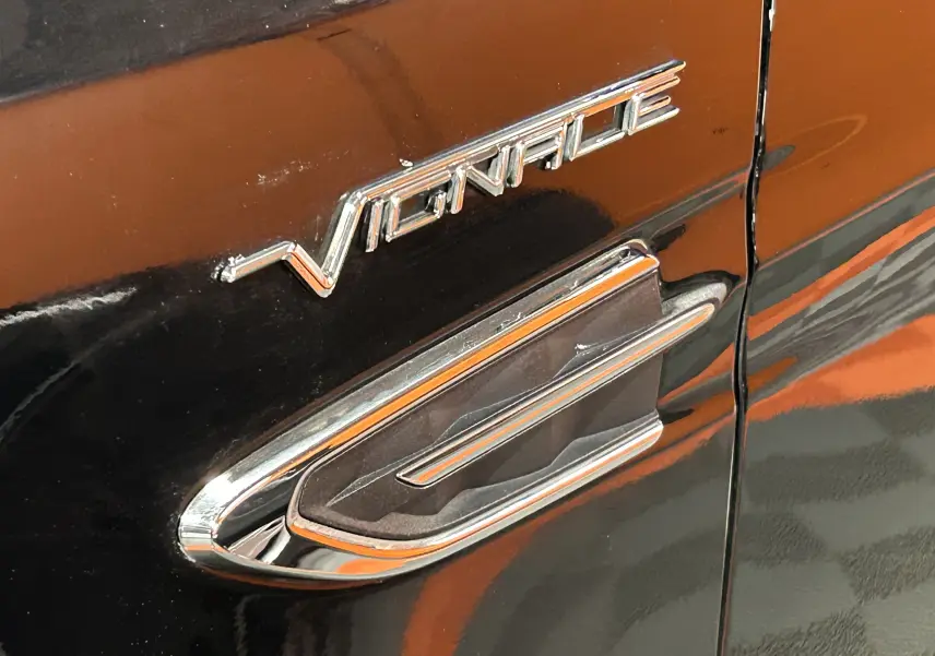 Gros plan sur l’inscription Vignale chromée sur la porte noire d’un Ford Kuga 2017 suréquipé.