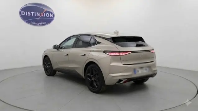 Vue 3/4 arrière droite d'une DS4 hybride E-Tense 225 gris clair avec jantes noires dans un studio blanc.
