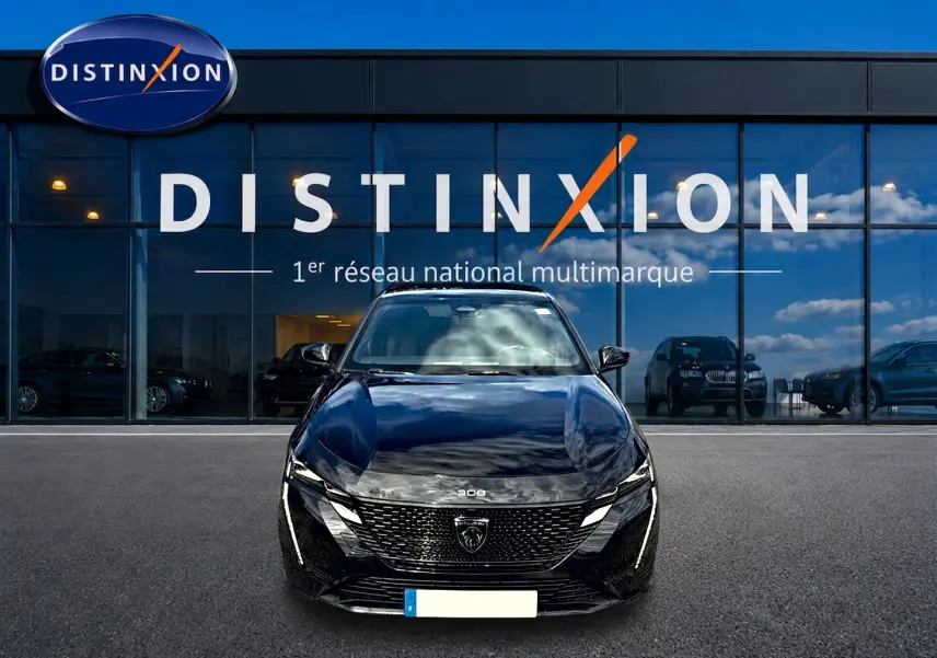 Vue avant d'une Peugeot 308 noire 2025 garée devant une vitrine avec logo Distinxion visible en arrière-plan.