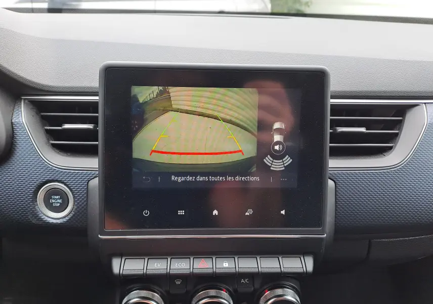 Écran central affichant la caméra de recul dans un Renault Arkana bleu Zanzibar 2023, avec tableau de bord noir texturé.