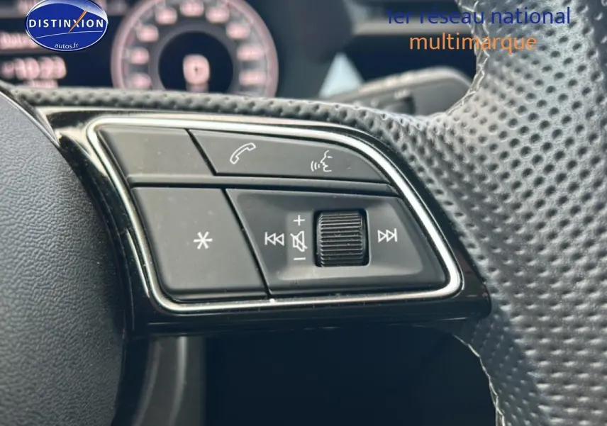 Gros plan sur les commandes audio au volant cuir perforé de l'Audi A3 Sportback noir 2024.