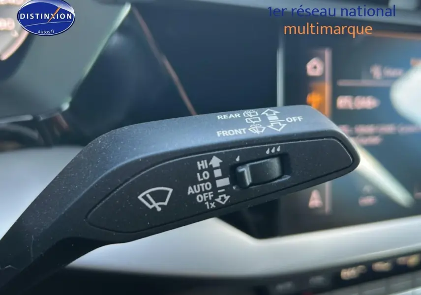 Gros plan sur la commande d'essuie-glace noire dans l'habitacle de l'Audi A3 Sportback 2024 avec tableau de bord numérique flou.