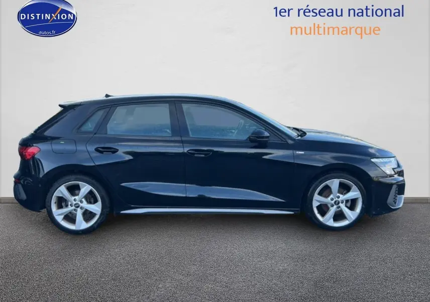 Profil droit d'une Audi A3 Sportback noire 2024 avec jantes alliage 5 branches et finition S line.