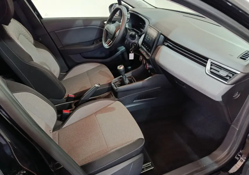 Intérieur avant droit de la Renault Clio Evolution Blue dCi 100 2025, sièges gris et tableau de bord moderne avec écran tactile.