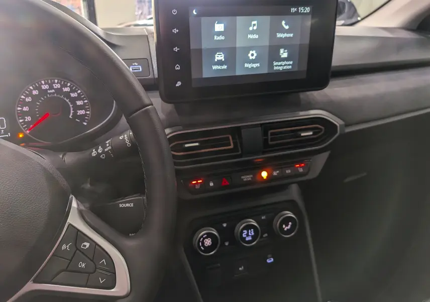 Vue intérieure côté conducteur du tableau de bord de la Dacia Sandero Stepway 2025 avec écran tactile et commandes climatisation.
