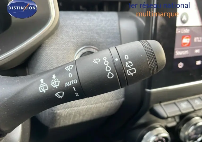 Gros plan sur la manette d’essuie-glace noire dans l’habitacle de la Renault Clio rouge Désir Métal 2025.