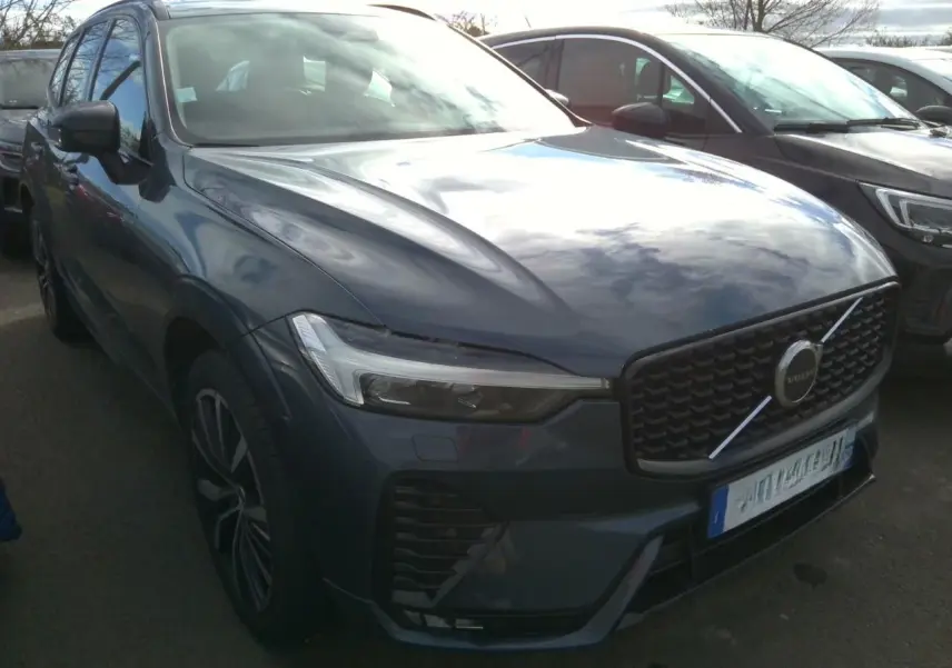 Vue 3/4 avant gauche d'un Volvo XC60 bleu avec calandre noire laquée et jantes alliage 20 pouces en Y.
