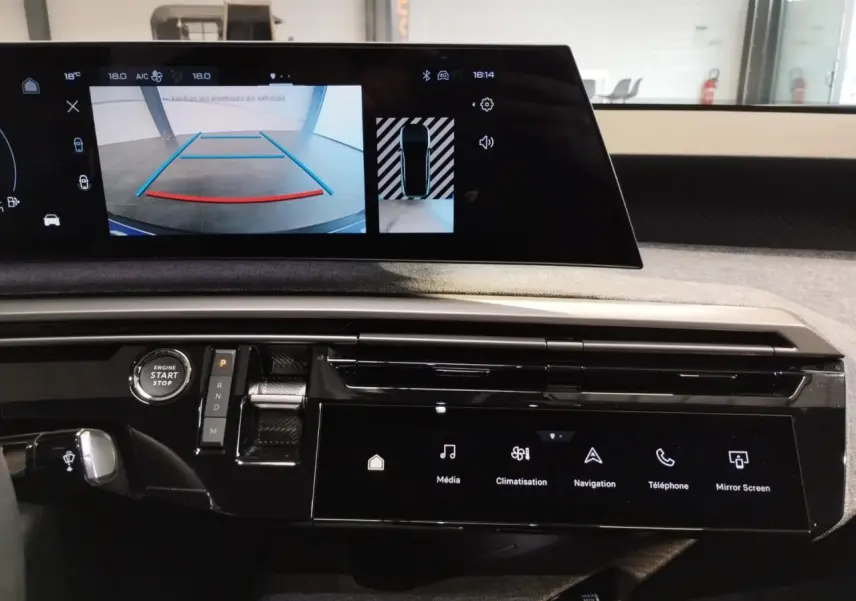 Vue rapprochée de la console centrale et écran incurvé du Peugeot 3008 gris Artense 2024 avec affichage caméra de recul.