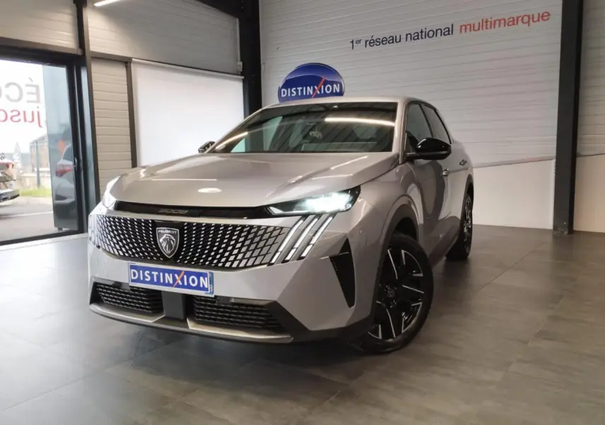 Peugeot 3008 gris Artense vue 3/4 avant en intérieur avec calandre distinctive et feux LED allumés.