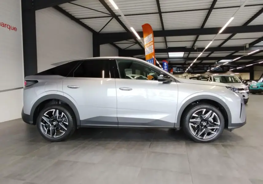 Vue de profil côté gauche du Peugeot 3008 gris Artense avec jantes alliage noires et toit noir en concession.
