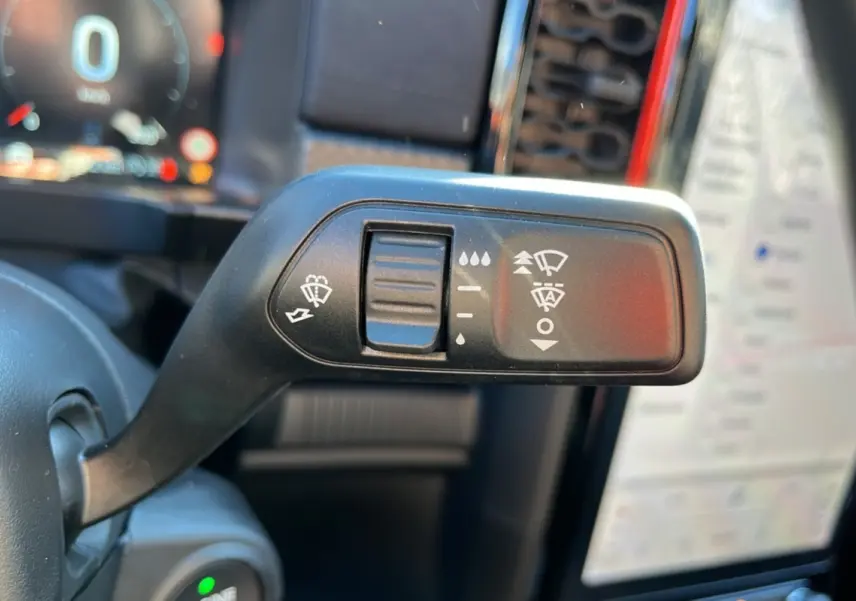 Gros plan sur la commande des essuie-glaces du Ford Ranger Raptor 2026, intérieur avec écran tactile en arrière-plan flou.