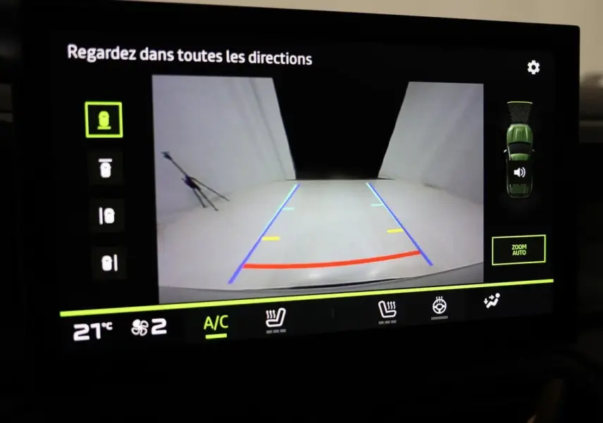 Écran de caméra de recul du Dacia Duster 2024 affichant les lignes de guidage et vue arrière en intérieur véhicule.