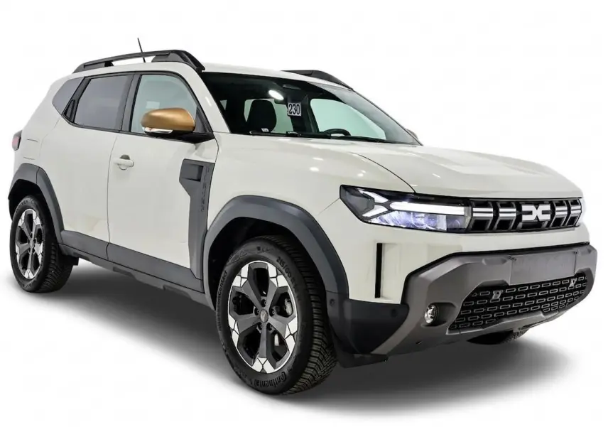 Vue 3/4 avant droite du Dacia Duster 2024 couleur Sandstone avec rétroviseur doré et jantes bi-ton.