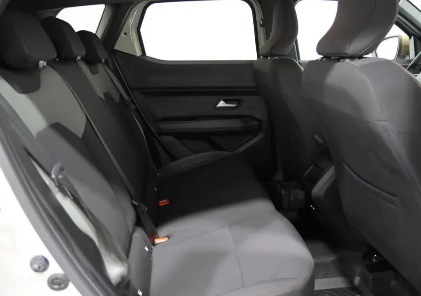 Vue intérieure arrière du Dacia Duster 2024, sièges tissu noirs avec surpiqûres contrastantes, habitacle spacieux et sobre.