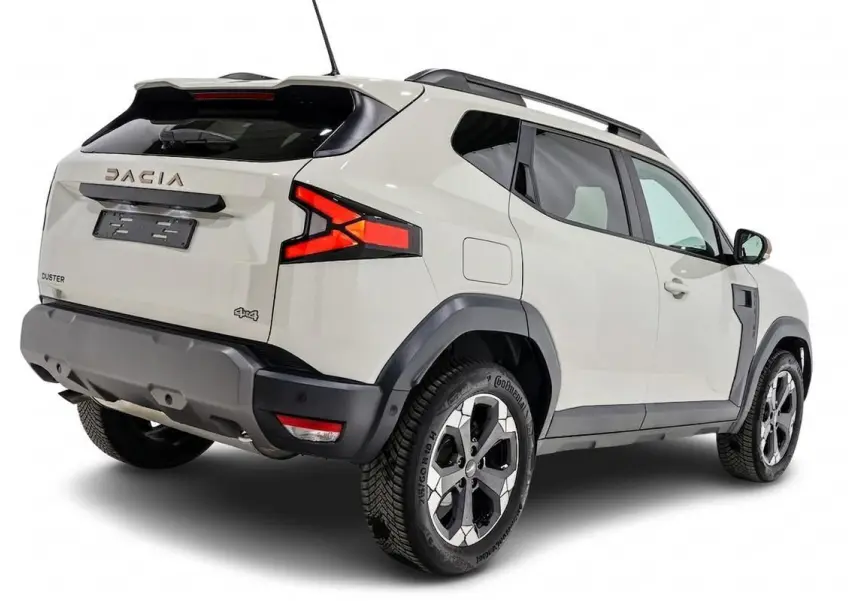Vue 3/4 arrière droit du Dacia Duster 2024 couleur Sandstone avec jantes bi-ton et barres de toit noires.