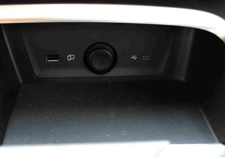 Gros plan sur le volant perforé et les commandes tactiles du MG ZS 1.5L Hybrid+ 2026, intérieur noir avec écran tactile.