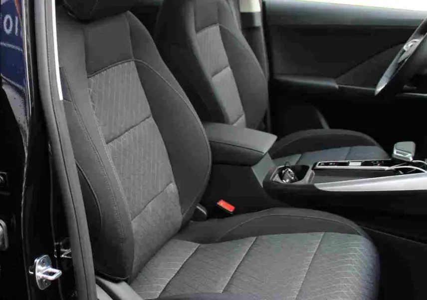 Vue arrière du coffre ouvert d'un MG ZS 1.5L HYBRID+ 197 ch en Pebble Black Metal, avec feux arrière allumés.