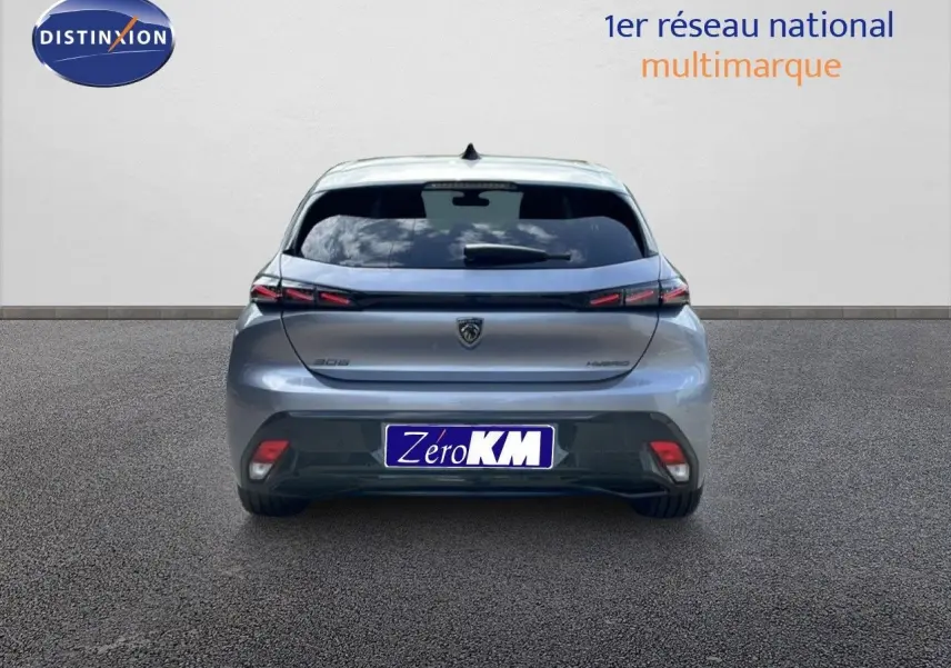 Vue arrière d'une Peugeot 308 1.2 Hybrid gris Artense métal, avec feux LED et logo central sur fond clair.