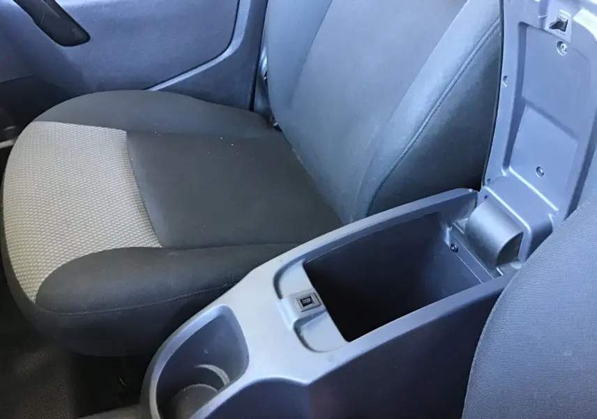 Vue rapprochée de l’intérieur du Renault Kangoo 2021, siège passager gris et console centrale ouverte noire.