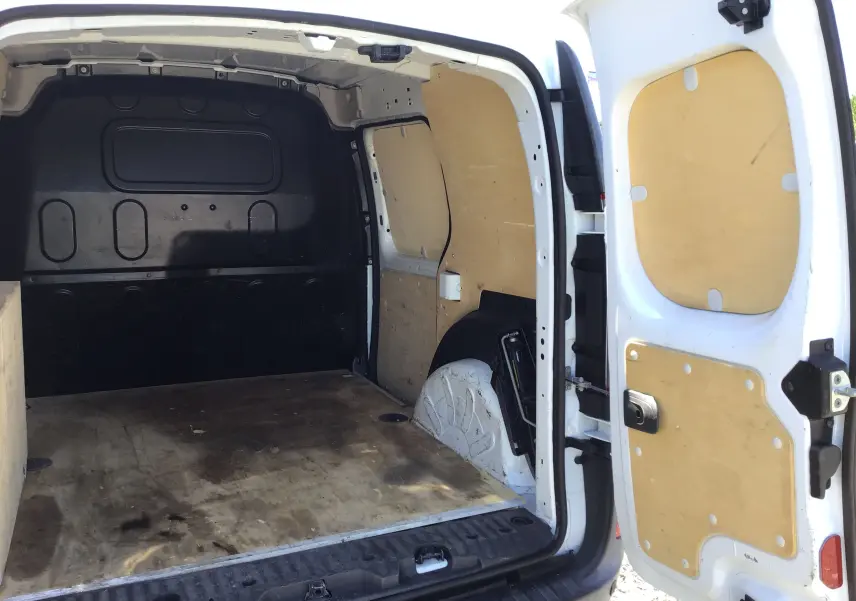 Vue arrière ouverte du Renault Kangoo blanc 2021 montrant l'espace de chargement avec revêtement bois intérieur.