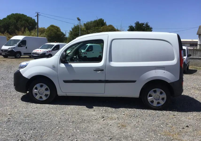 Vue de profil côté gauche d’un utilitaire Renault Kangoo blanc, avec porte latérale pleine et jantes acier.