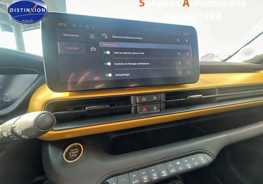 Tableau de bord intérieur du Jeep Avenger jaune foncé, avec écran tactile affichant les aides à la conduite.