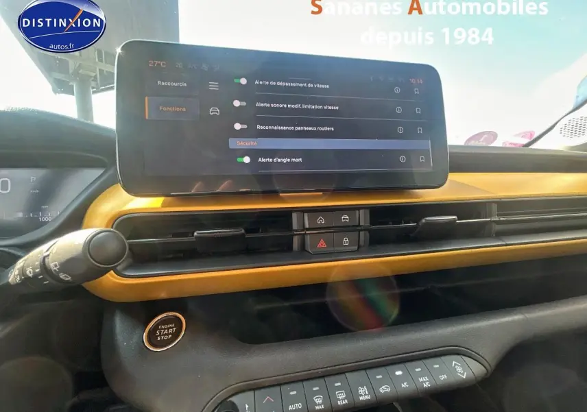 Vue intérieure du tableau de bord jaune foncé du Jeep Avenger 2025 avec écran tactile et bouton start/stop.