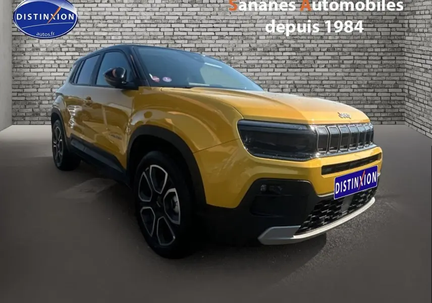 Jeep Avenger jaune foncé en 3/4 avant droit avec calandre gloss black et jantes distinctives.