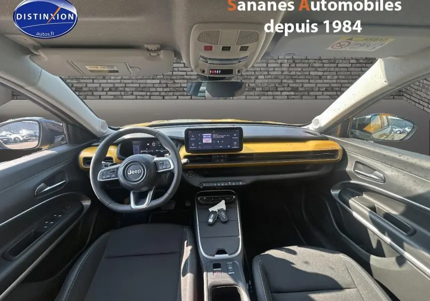 Vue intérieure avant du Jeep Avenger 2025 avec tableau de bord jaune foncé et volant multifonction.