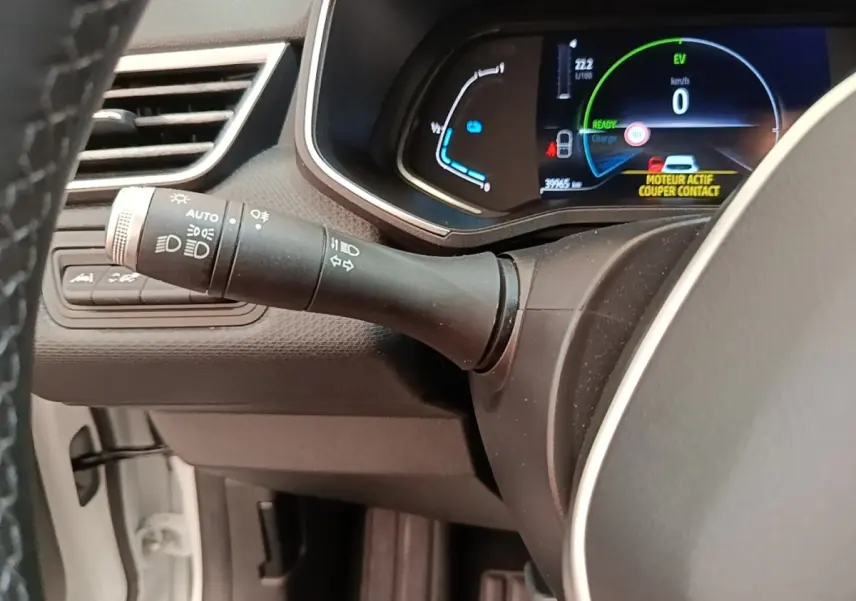 Vue rapprochée du combiné d'instruments et du commodo gauche de la Renault Clio Business E-TECH 140 blanche, affichage numérique.