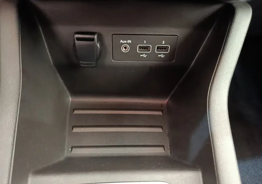 Gros plan sur la console centrale de la Renault Clio Business E-TECH 140, montrant ports USB et prise Aux-In.