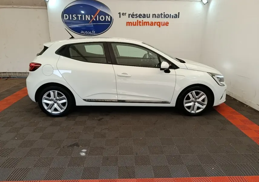 Profil droit d'une Renault Clio Business E-TECH 140 blanche de 2021, avec jantes alliage et logo Distinxion en arrière-plan.