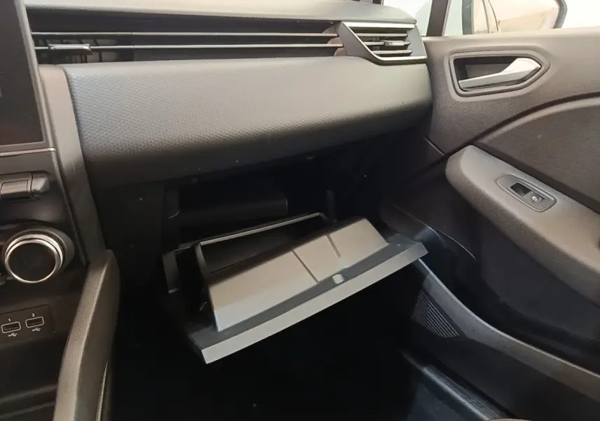 Intérieur de la Renault Clio Business E-TECH 140 2021, vue côté passager sur la boîte à gants ouverte et tableau de bord noir.