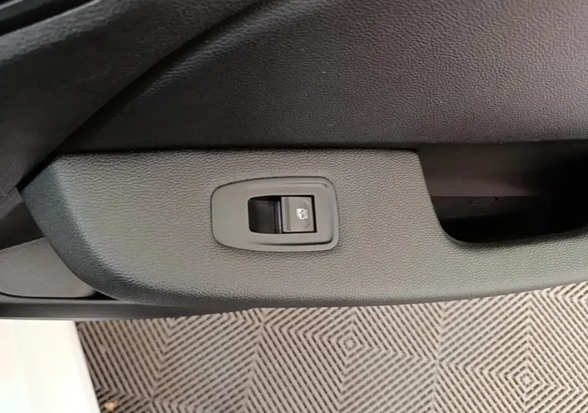 Bouton de verrouillage centralisé sur la porte intérieure côté conducteur d'une Renault Clio Business E-TECH blanche.