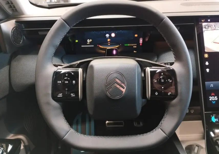 Vue rapprochée du volant noir multifonctions du Citroën C5 Aircross 2026 avec tableau de bord numérique et écran tactile.
