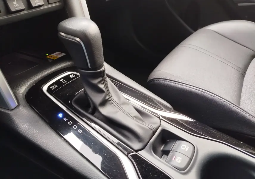 Gros plan sur la console centrale de la Toyota Corolla Cross Hybrid 140 Luxury Limited 2025, avec levier de vitesse automatique en cuir noir.