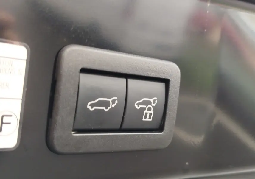 Boutons de commande du hayon avec fonction ouverture et verrouillage sur Toyota Corolla Cross noir.