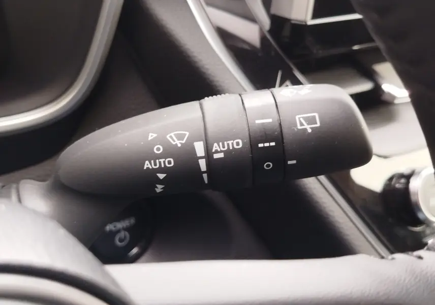 Gros plan sur la commande d’essuie-glace automatique du Toyota Corolla Cross Hybrid 140 Luxury Limited 2025, intérieur noir.